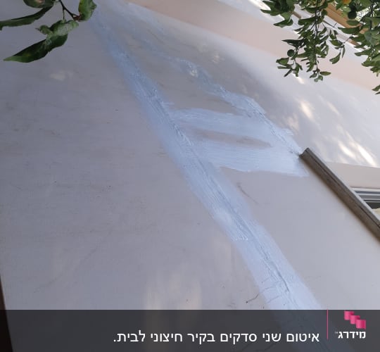 קיר עם איטום לבן לאורך סדק
